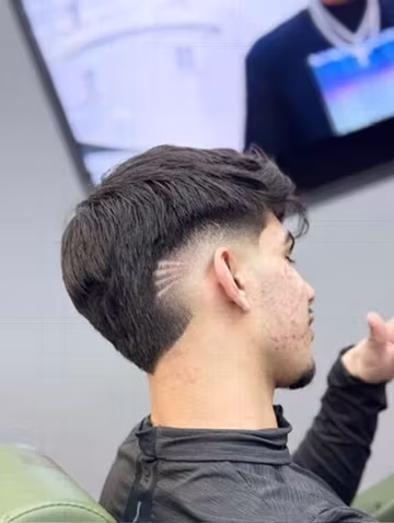Taper haircut with a design at Prestige Barbers Yardley